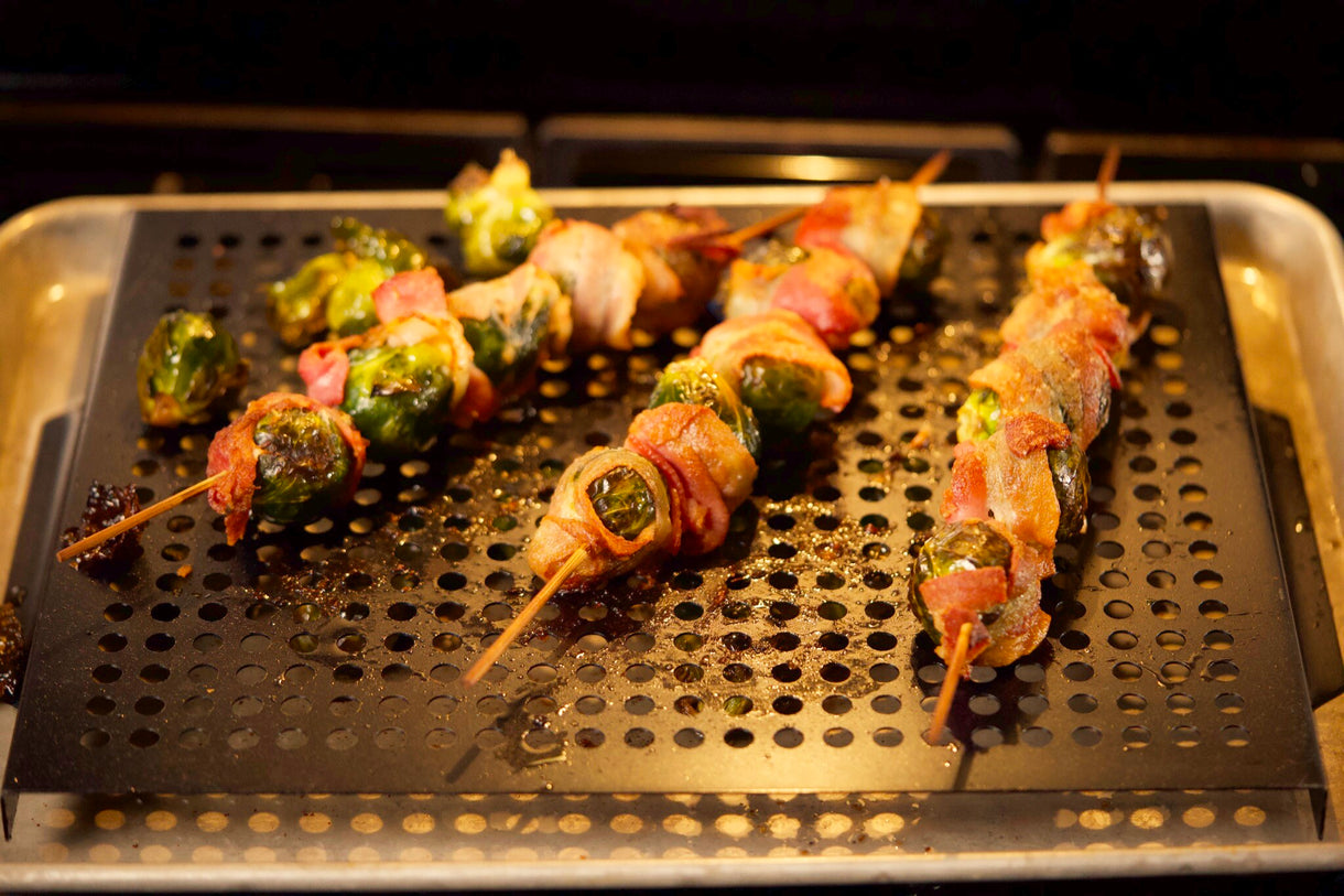 Brussels sprout and bacon skewers roasting on a grill pan